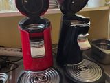 two coffee makers sitting on top of a stove
