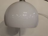 a white lamp that is on the wall next to a picture