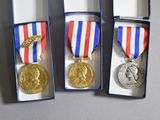 three medals that are in a box on a table