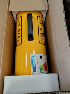 une canette jaune posée dans une boîte en carton sur le sol