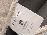 a label on the back of a jacket that is hanging from the back of a chair