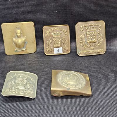 quatre boucles de ceinture en laiton et une boucle de ceinture en or ornée d'un blason