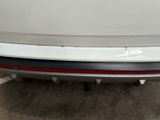 the rear end of a white car with a red tail light