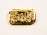 a close up of a gold bar on a white surface