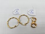 two pairs of gold hoop earrings and a pair of gold hoop earrings