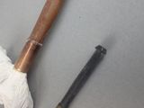 someone is holding a baseball bat and a pair of gloves on a table