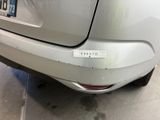 the rear end of a silver car with a sticker on it ' s bumper
