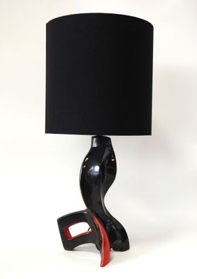 une lampe noire avec un pied rouge et un abat-jour noir