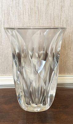 un vase en verre posé sur une table, avec du papier peint en arrière-plan