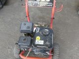 a small lawn mower sitting on the ground in a garage