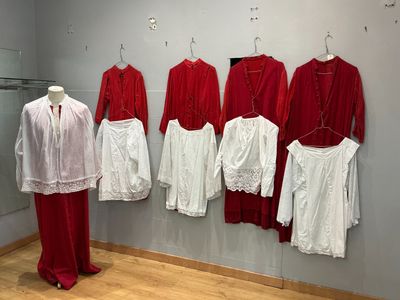 de nombreuses robes rouges et blanches exposées dans une pièce