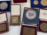 several silver and gold coins are sitting on a table next to other items