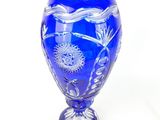 a blue vase that is sitting on a white surface