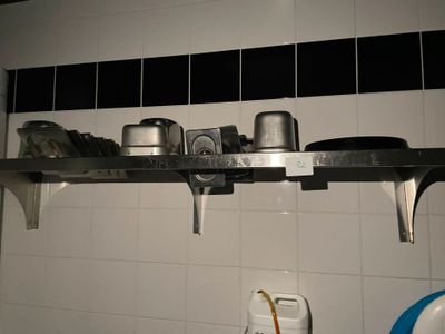 une étagère avec des casseroles et des poêles dans une cuisine