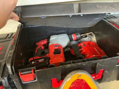 une boîte à outils contenant des outils et une personne tenant un marteau
