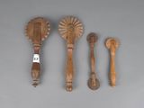 Plusieurs cuillères et spatules en bois sont alignées sur une surface grise