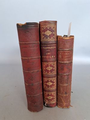 trois vieux livres sont empilés sur une table