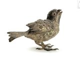 a silver bird that is standing on a white surface