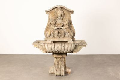 une statue représentant une femme assise au sommet d'une fontaine