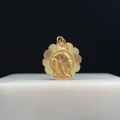 un gros plan d'une médaille d'or posée sur un socle blanc