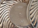 a silver plate with a silver lid sitting on top of a table