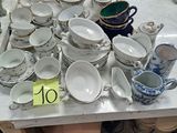 une table sur laquelle se trouvent beaucoup de plats et de tasses