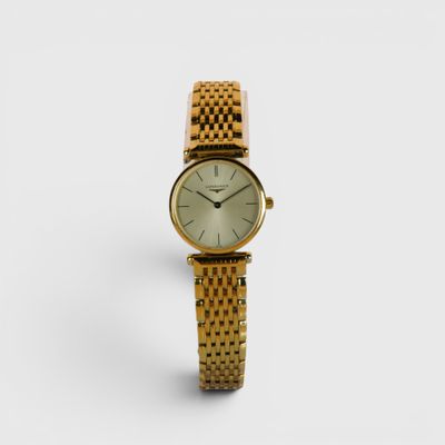 une photo d'une montre-bracelet pour femme posée sur une surface blanche
