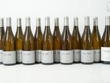 six bouteilles de vin blanc alignées sur une table