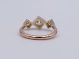a close up of a gold ring with two diamonds on it