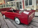 a red toy car that is sitting on a wooden table