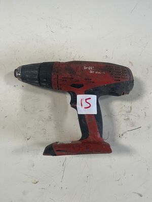 une image représentant une perceuse sans fil posée sur une surface blanche