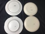 four white plates are sitting on a black table cloth