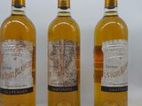 trois bouteilles de vin posées les unes à côté des autres sur une surface blanche