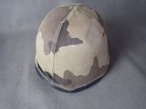 un casque orné d'un motif de camouflage, posé sur une table