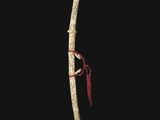 a close up of a wooden stick with a red ribbon on it