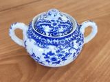 a small blue and white teapot on a wooden table