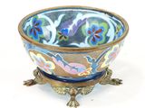 un bol bleu orné de fleurs, posé sur un socle