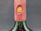 a bottle of wine that has a pink cap on it