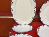 quatre assiettes et un bol posés sur une table rouge