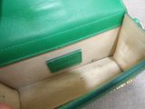 the inside of a green purse with a metal clasp