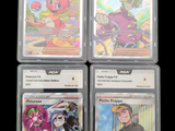 four different pokemon trading cards in plastic cases on a black background