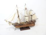 a model of a sailboat on a wooden stand
