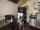 a kitchen with a stove, oven, sink, and cabinets
