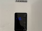 a white refrigerator with a digital clock on it