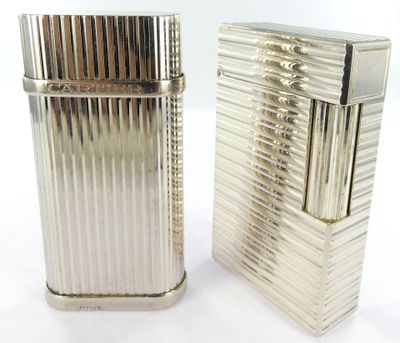 two silver lighters sitting next to each other on a white surface