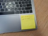 a laptop computer with a sticky note on the keyboard