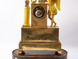 a gold clock with an angel on top of it
