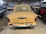 a yellow car parked in a garage with other cars
