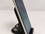 a close up of a cell phone on a stand on a table