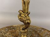 an antique brass table lamp with a glass shade on top of it